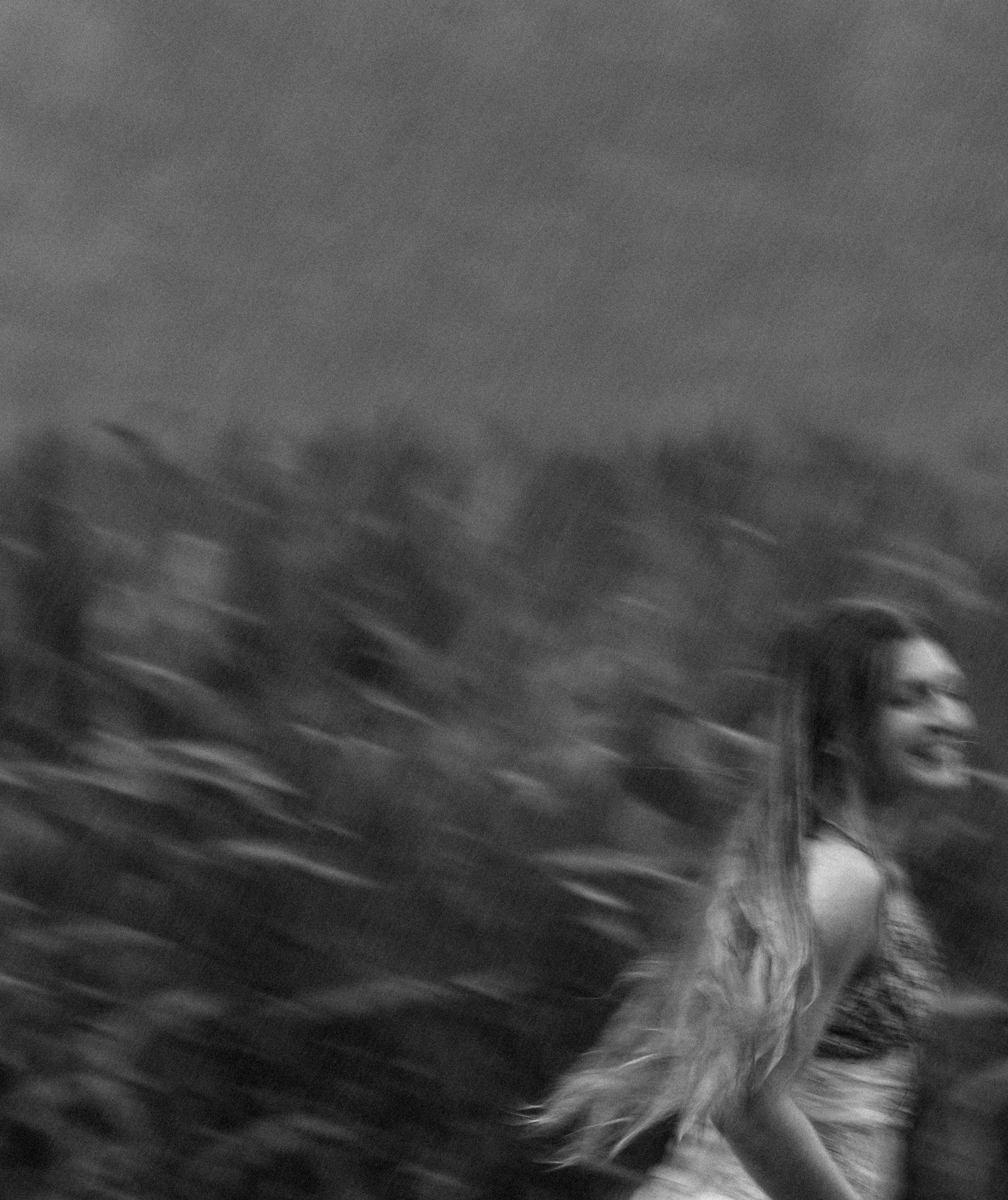 Black and white long-exposure portrait, motion blur mid-turn