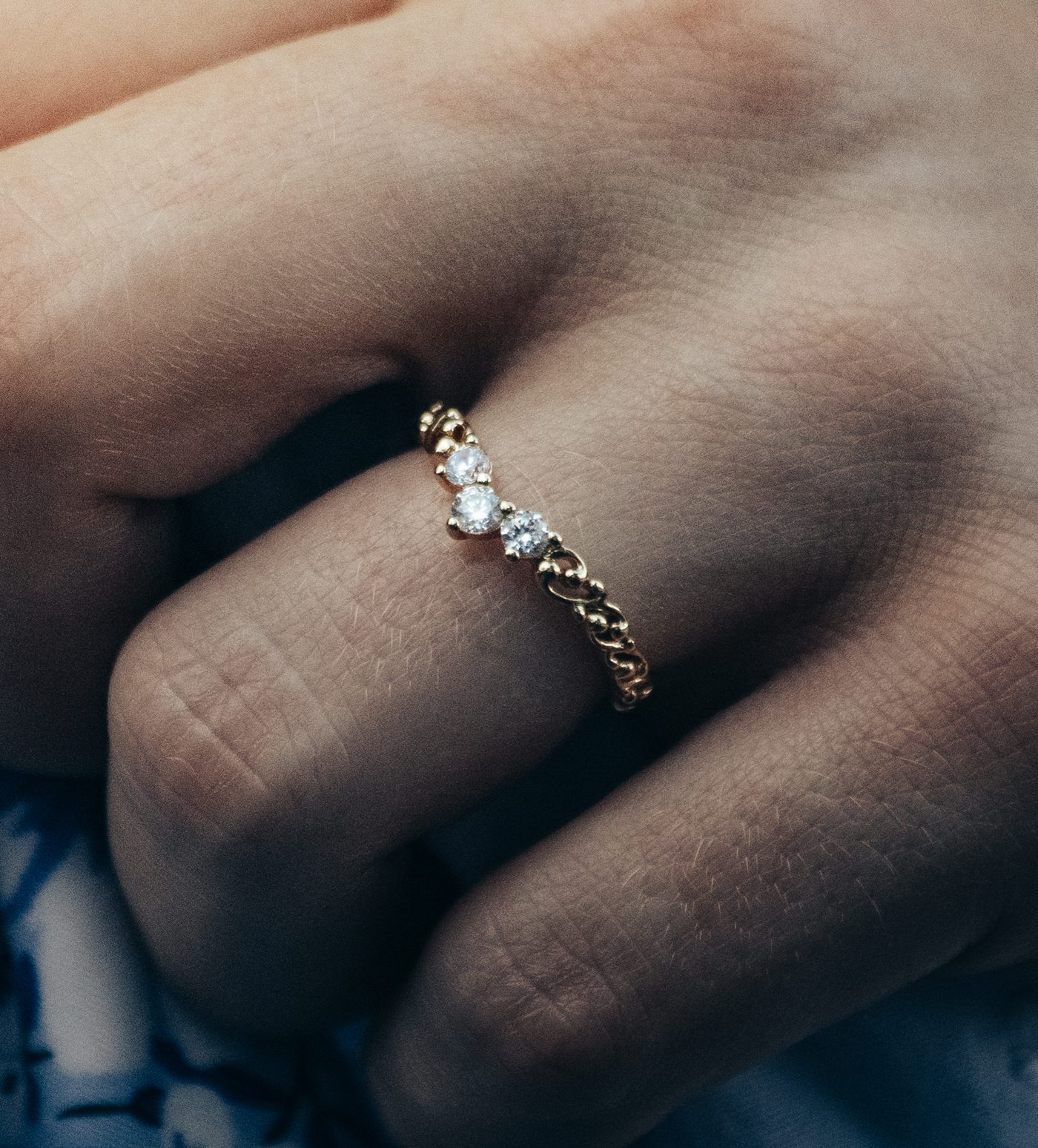 Macro detail of a gold ring with diamonds on a hand